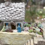 小さな家のミニチュアと多肉植物が組み合わされたナチュラルなガーデン風アレンジ