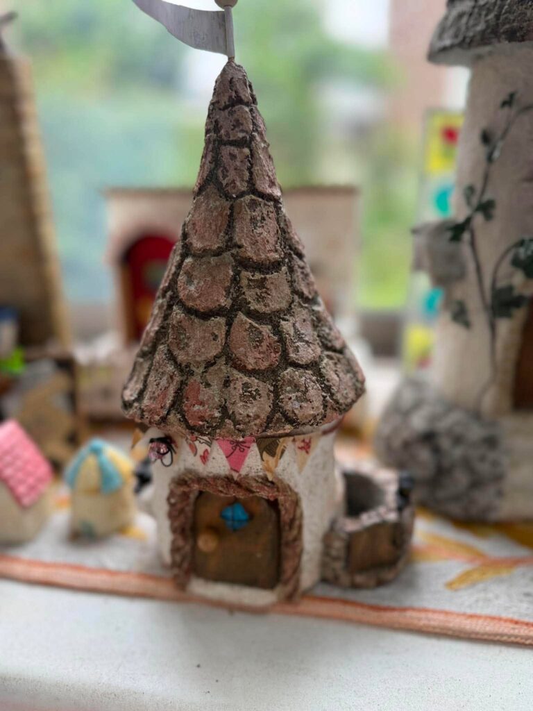 石積み風の円すい屋根と小さな扉が特徴的な、手作りのミニチュアハウス
